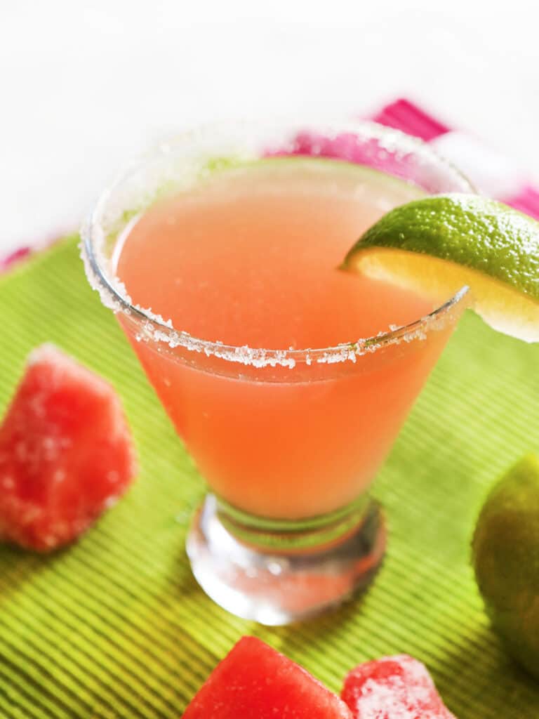 Watermelon martini with a lime wedge shown. 