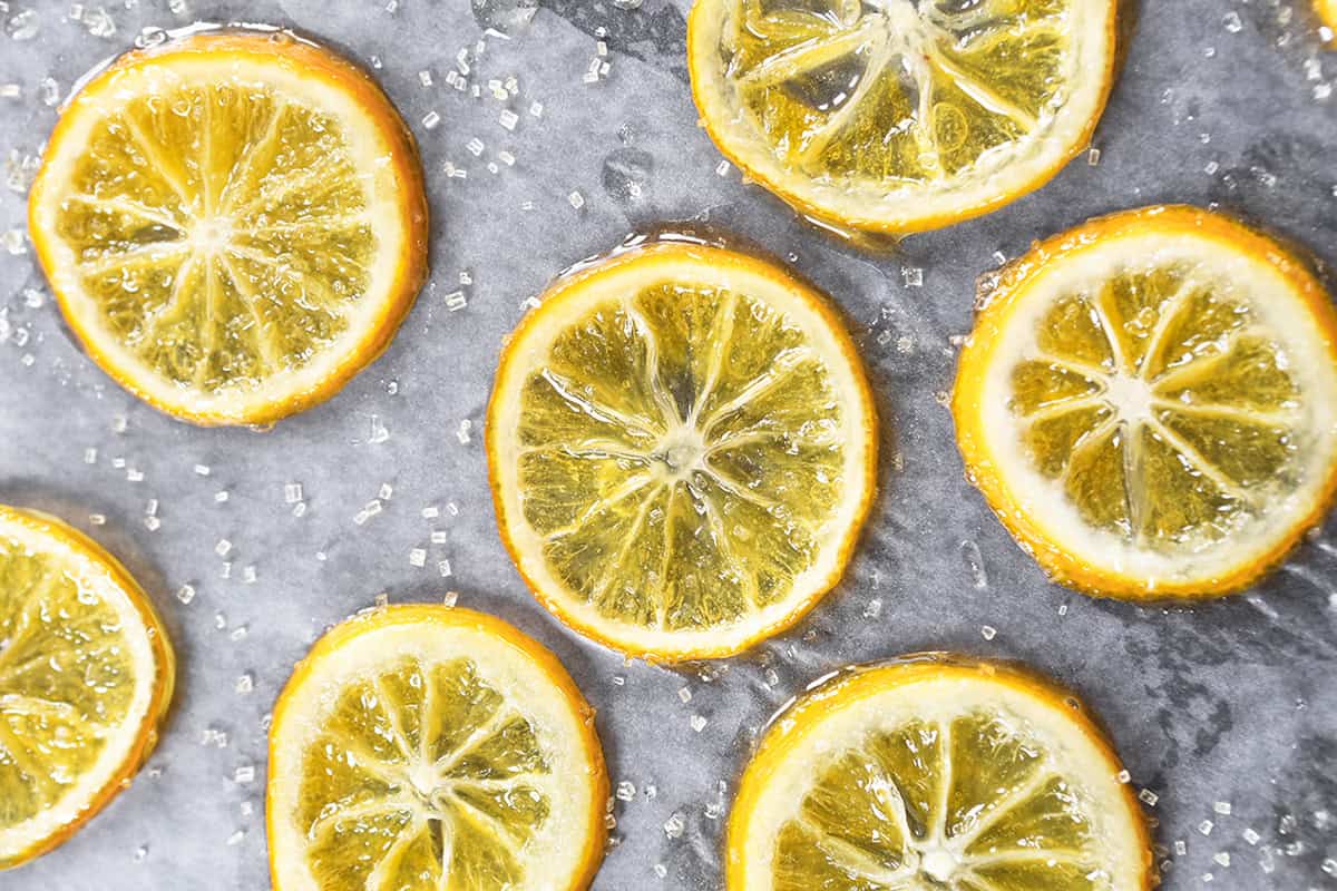 Close-up of candied lemon slices on parchment paper.