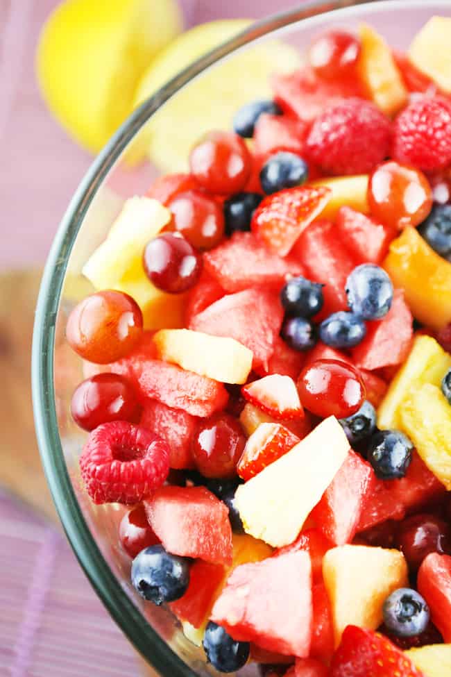 looking down into a bowl of fruit salad with watermelon, graphes, pineapple and more.