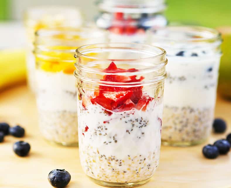 Overnight oatmeal in glass jars with fresh fruit on top. 