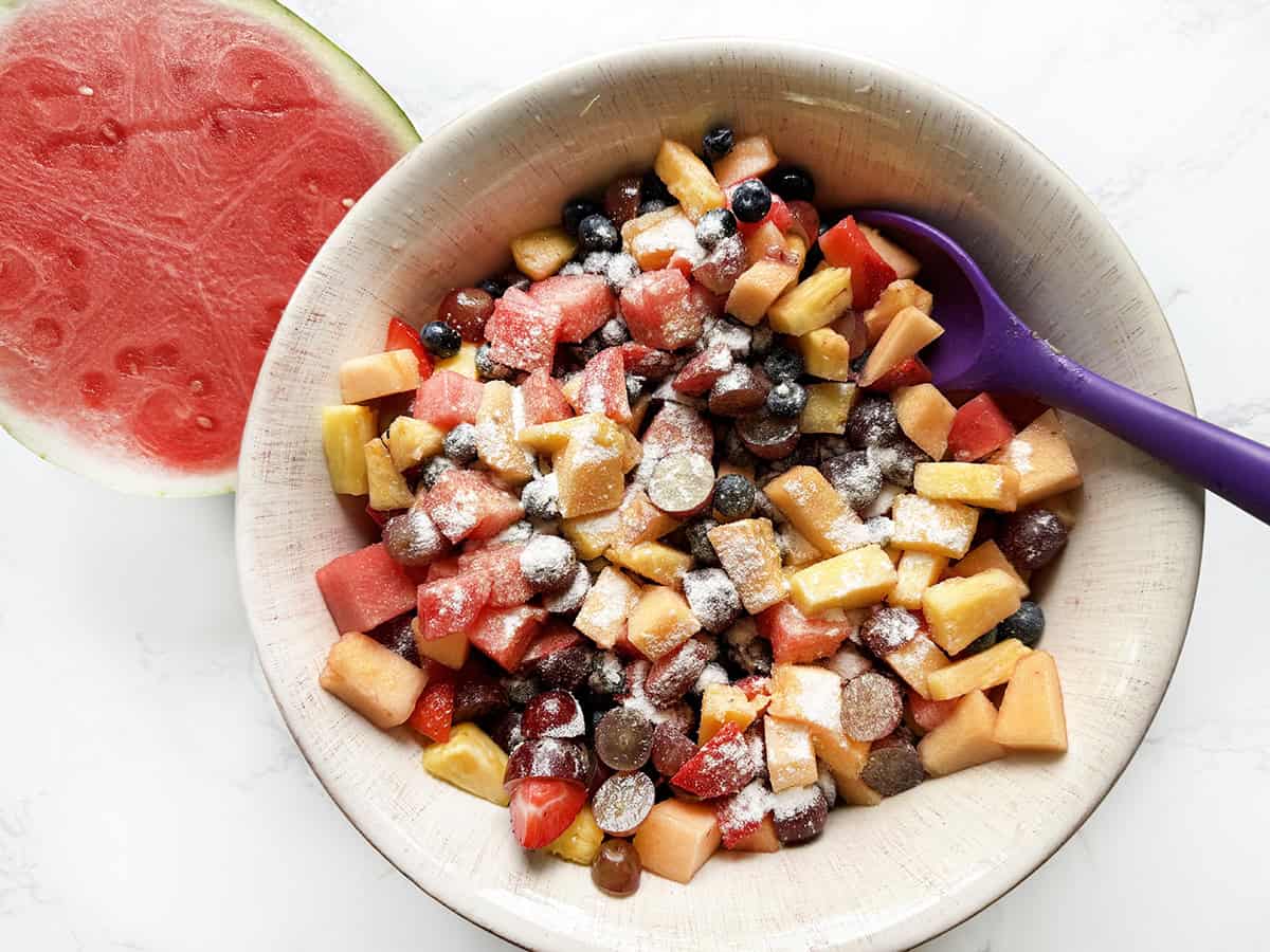 Chopped fruit in a bowl, with pudding mix sprinkled over the top.