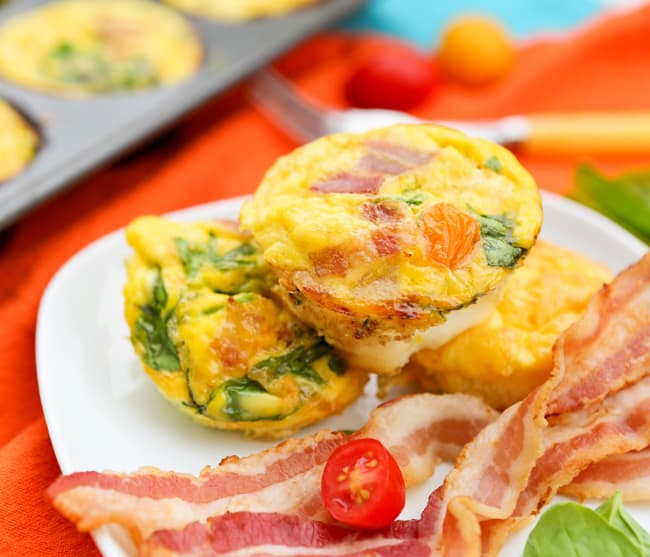 Omelets on the go served on a plate with strips of bacon. 