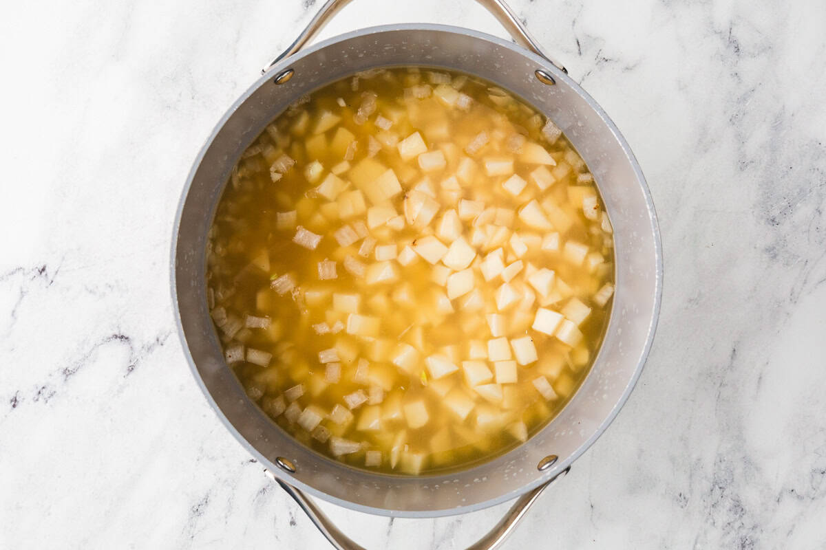 Potatoes and broth in a saucepan.