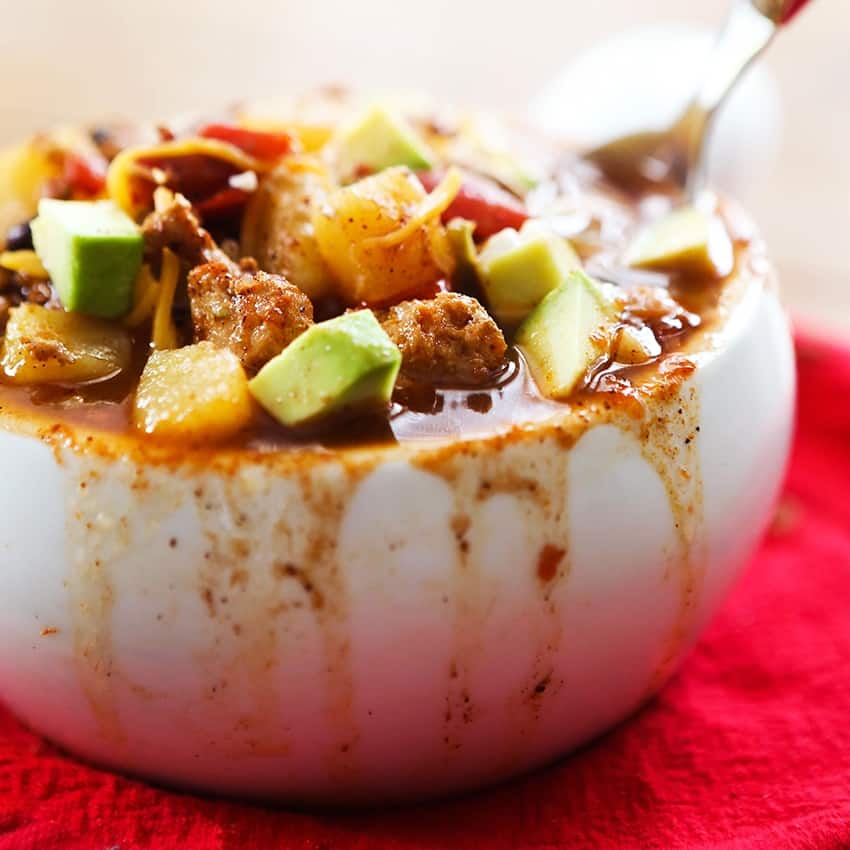 Steamy bowl of turkey chili with chunks of sweet potatoes, avocado and turkey filling the bowl. 
