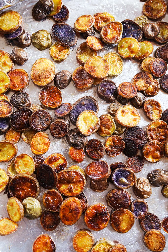 sheet pan of baked potato chips with sea salt sprinkled on top