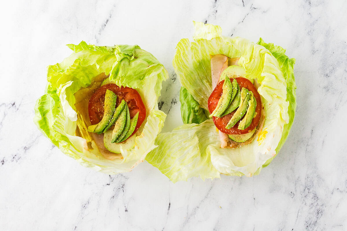 Iceberg lettuce "bowls" with veggies and deli meat inside.
