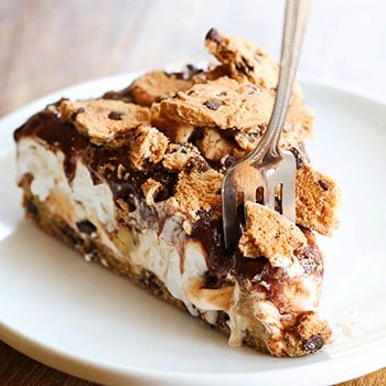 single slice of cookie dough ice cream cake on a plate with a fork removing a bite