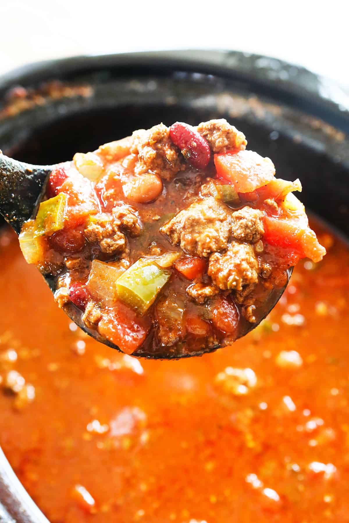 Ladle scooping chili out of a pot.