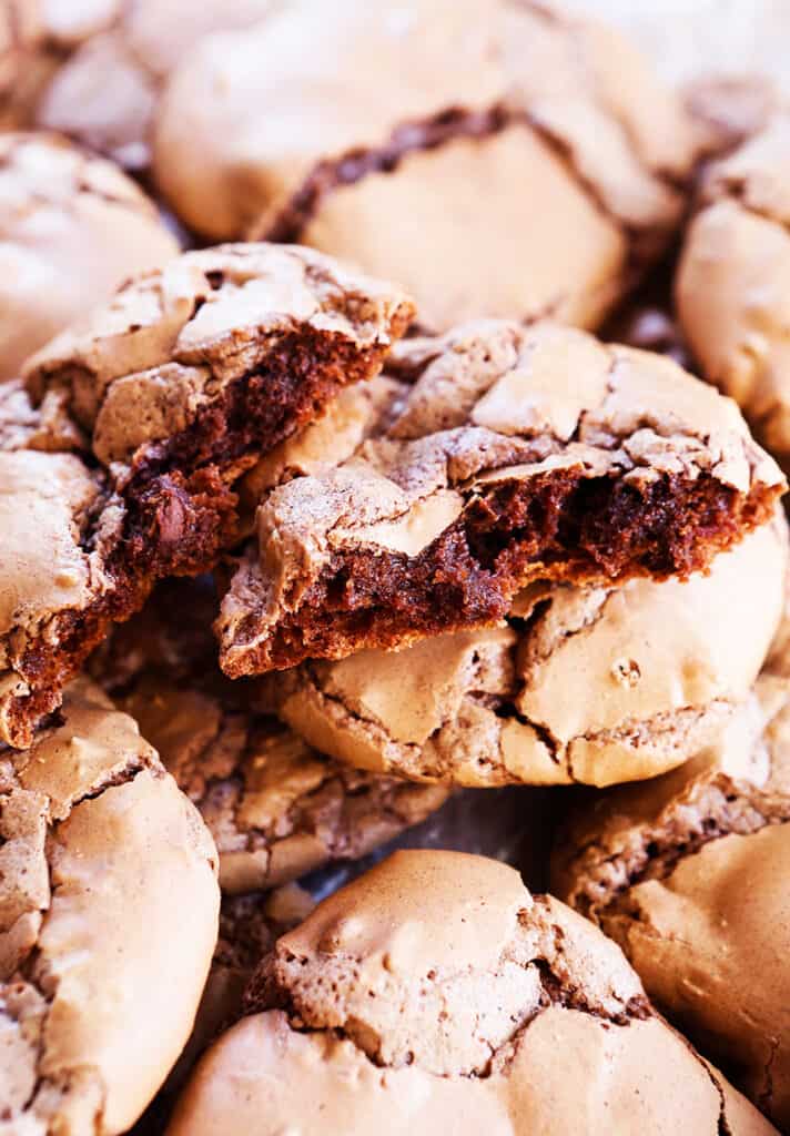 Stack of chocolate brownie cookies with one of them split in half. 