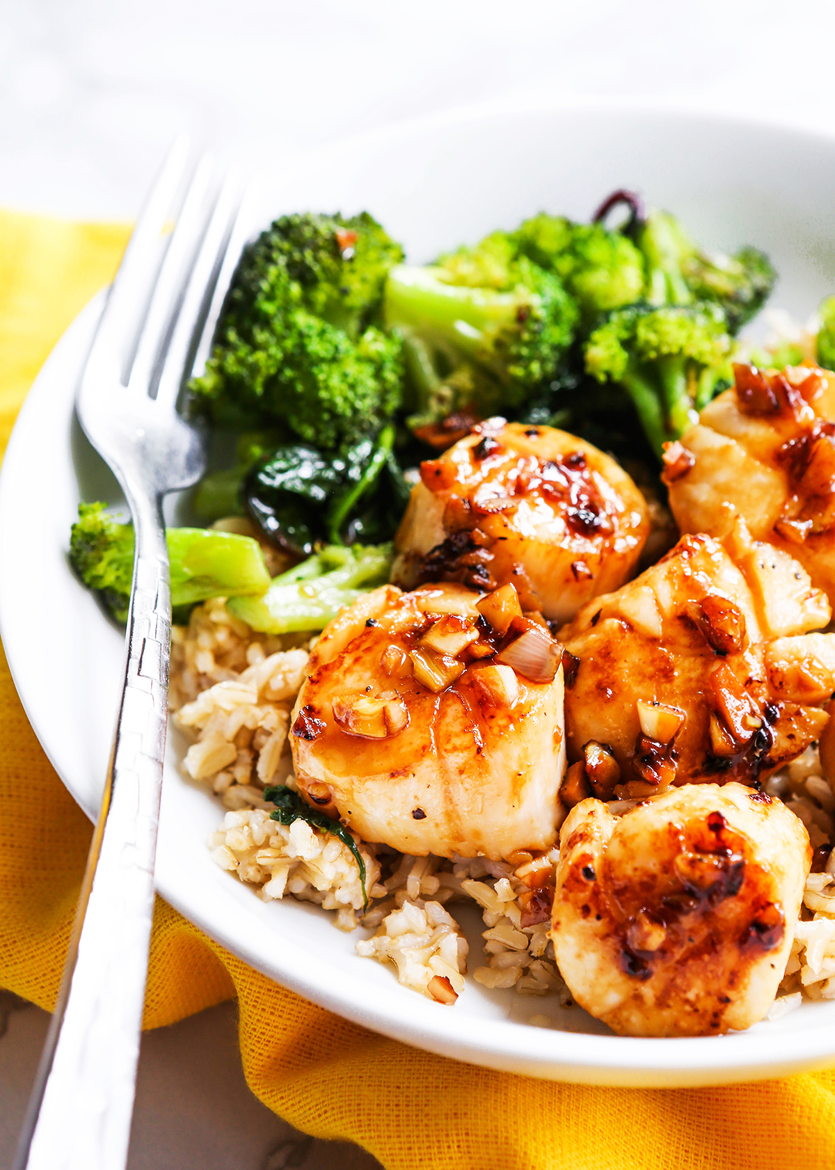 Plate filled with seared scallops, rice and broccoli.