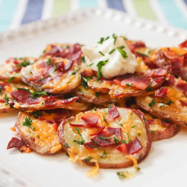 Loaded baked potato rounds served on a platter. 