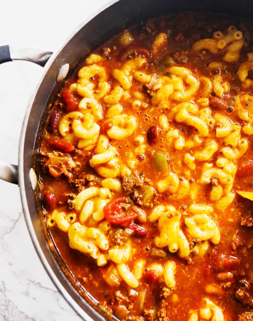 top view of large saucepan filled with macaroni and cheese and chili.