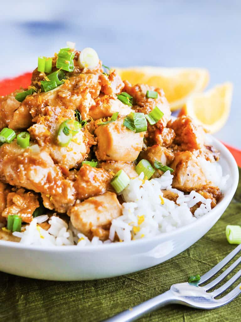 Orange chicken topping white rice served with it. 