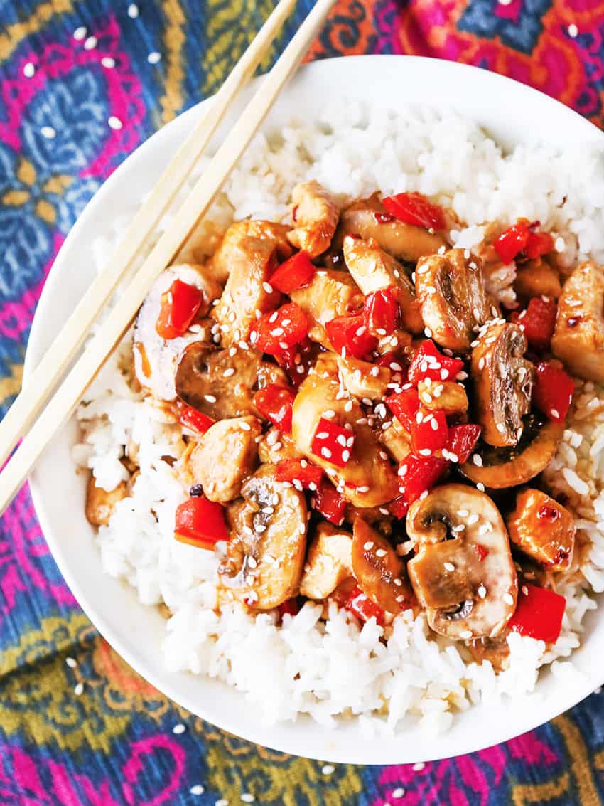 Plate of hoisin chicken with white rice, next to a pair of chopsticks.