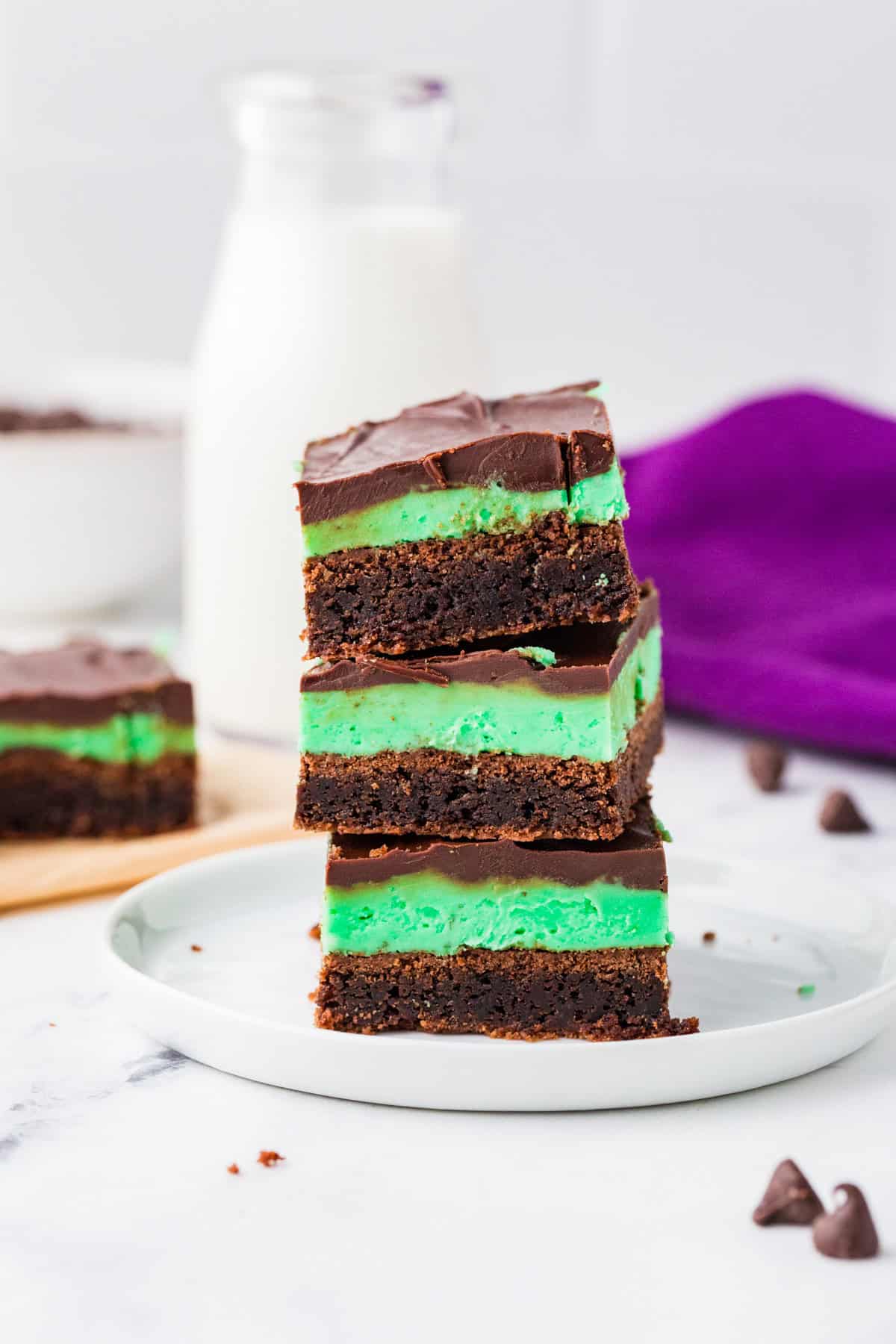 Stack of three chocolate mint brownies on a plate.