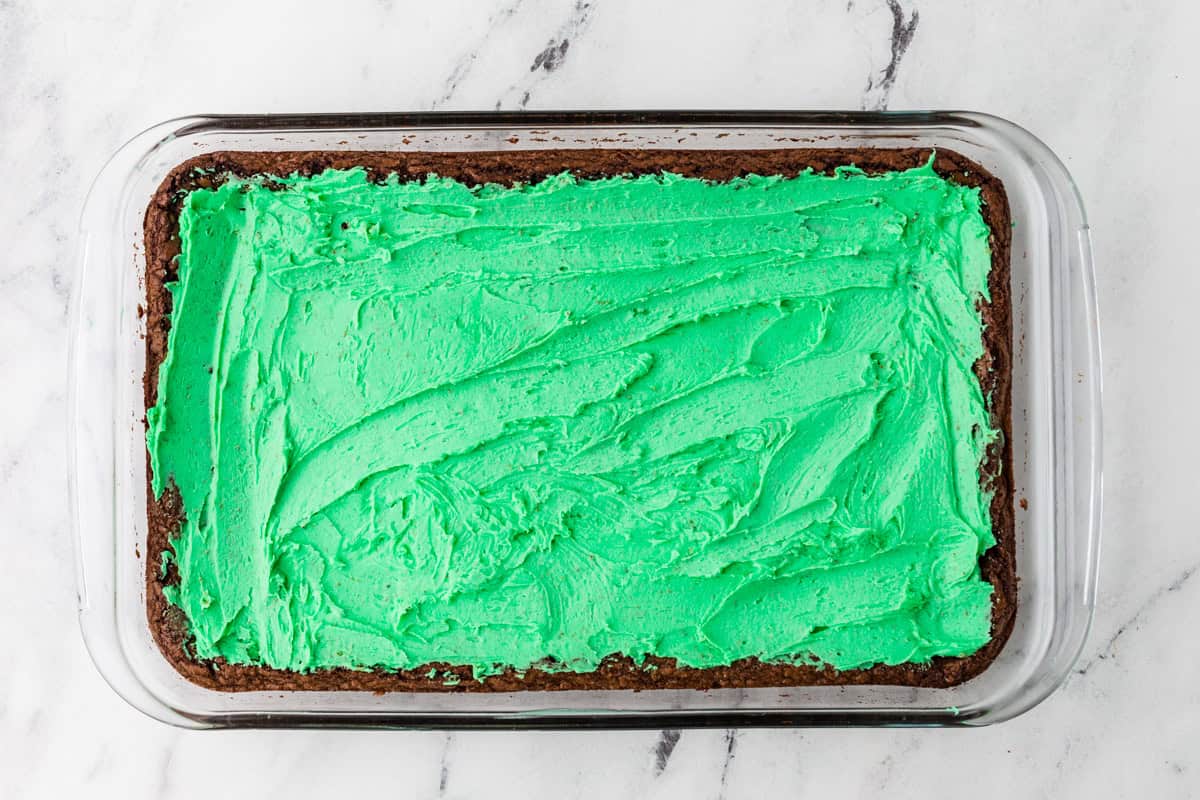 Green mint frosting spread in a single layer over brownies.