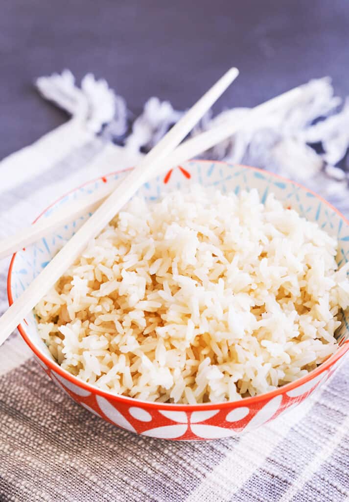 Small bowl of white rice with chopsticks on the side. 
