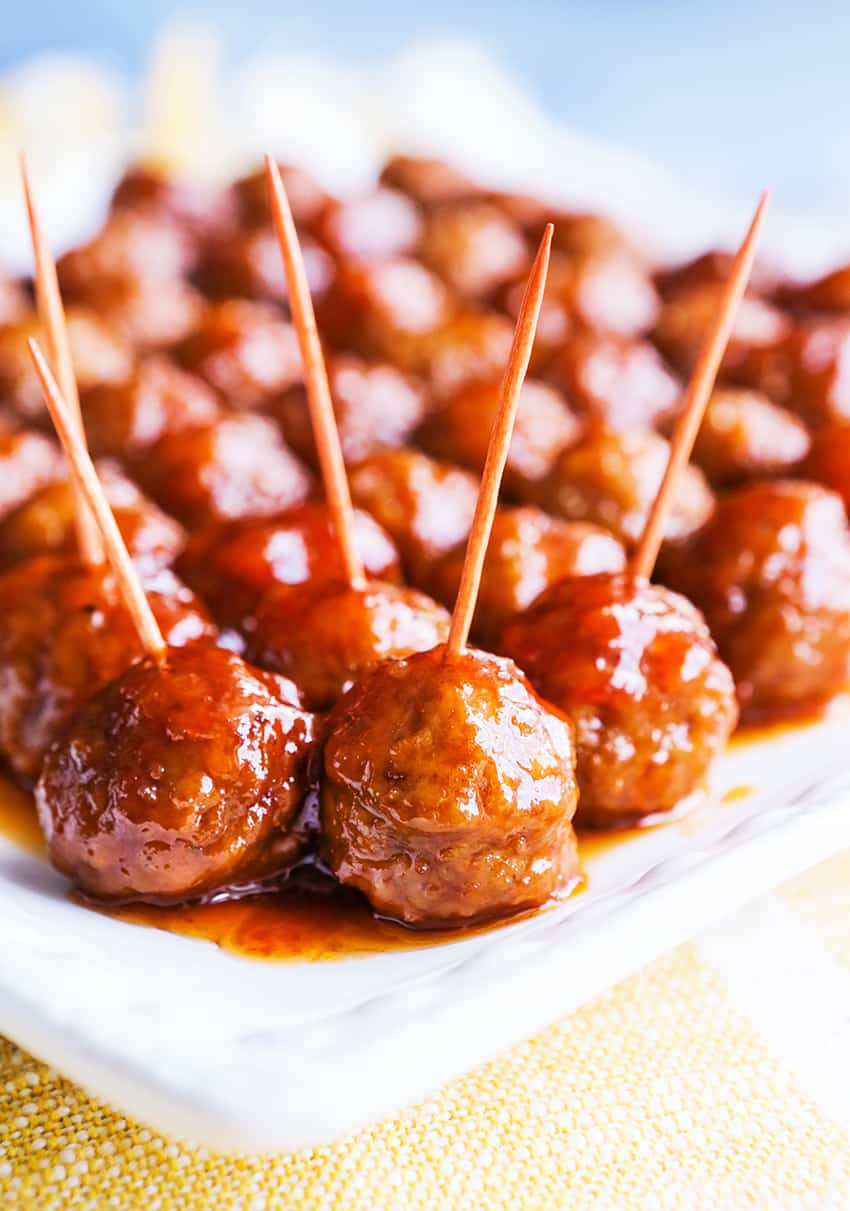 Toothpicks stuck in individual meatballs on a platter. 