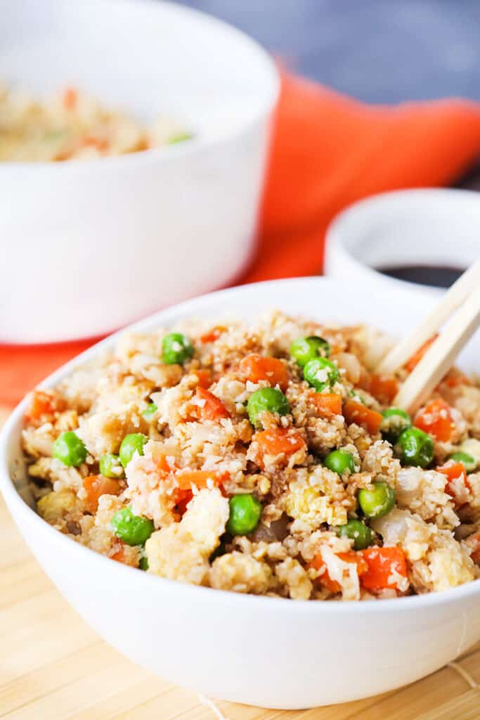 chopsticks in a bowl of cauliflower fried rice