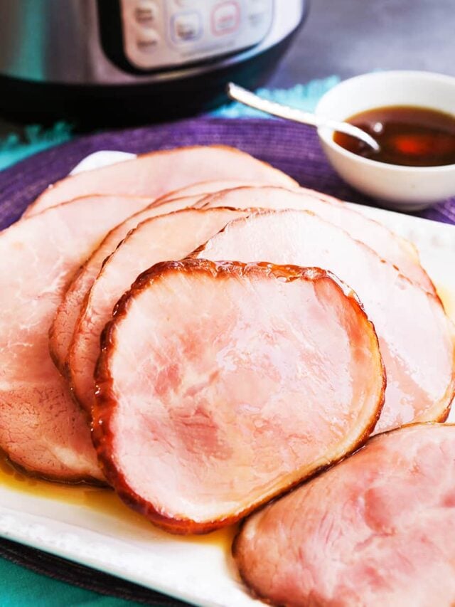 Plate of sliced ham laying in front of an instant pot. 
