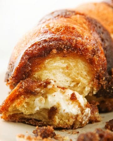 Close-up of a sliced monkey bread with cream cheese filling and caramelized exterior.