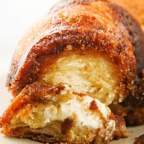 Close-up of a sliced monkey bread with cream cheese filling and caramelized exterior.
