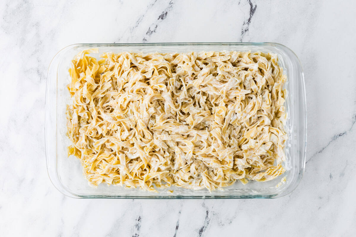 Noodles with sauce in a glass baking dish.