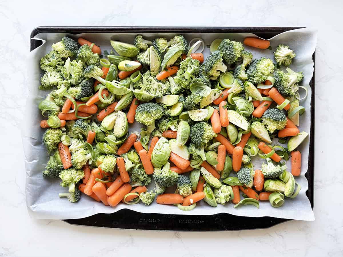 Raw chopped vegetables on a baking sheet, ready for baking.