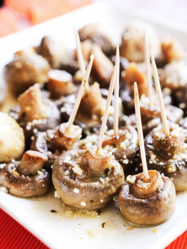 Toothpicks sticking out of instant pot mushrooms sitting on a serving platter. 