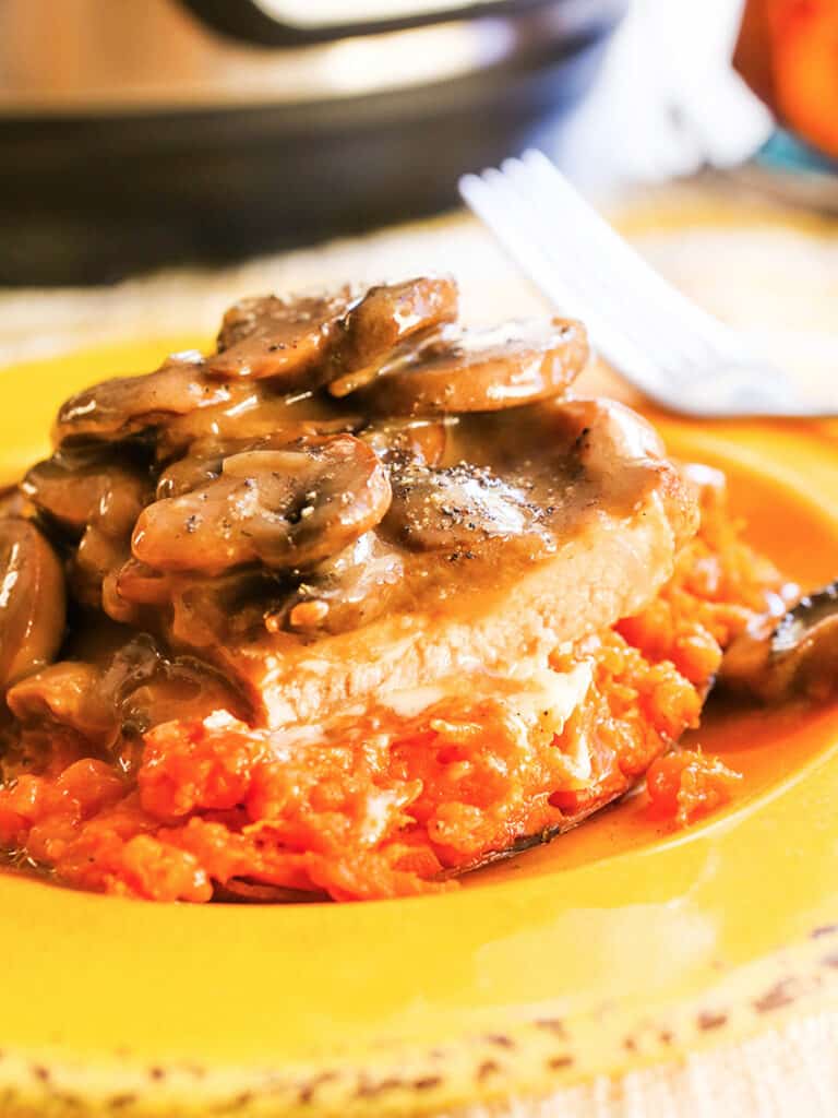 Pork chops with gravy and mushrooms served over potatoes. 