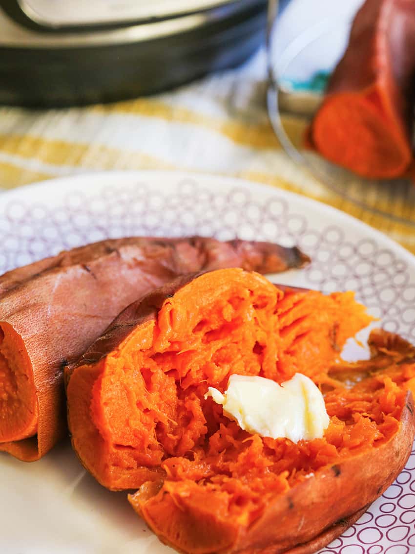 Sweet potatoes cooked in the instant pot cut in half and a pat of butter melting over the top. 