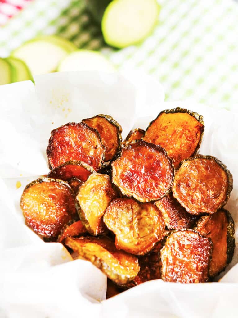 Basket of zucchini chips inside parchment paper in a basket. 