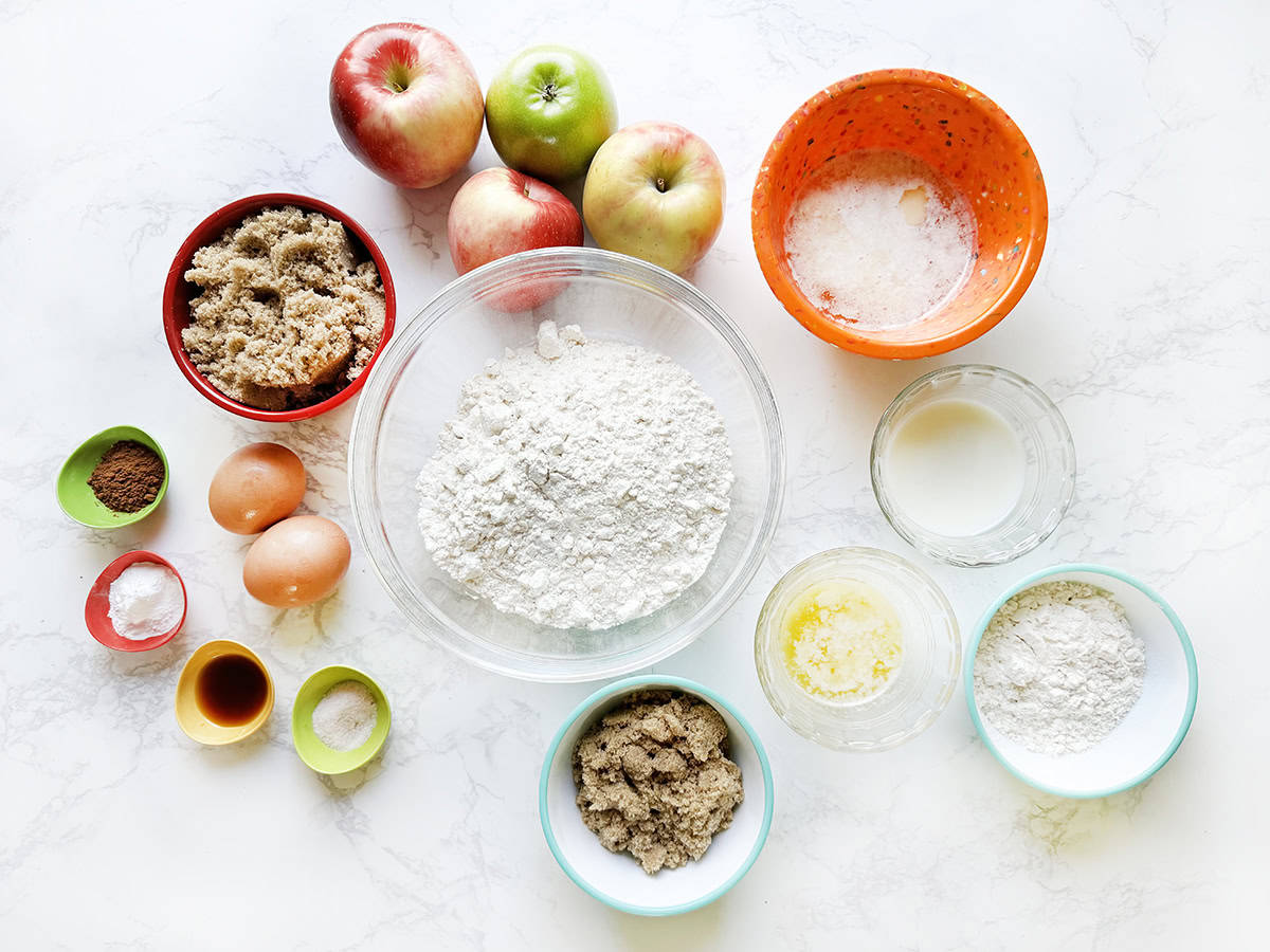 Apple pie bread ingredients in individual bowls on a white counter.