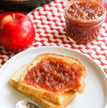 Apple butter spread on toasted bread with apples and an Instant Pot in background.