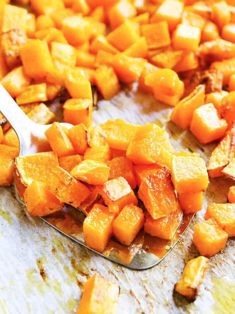 baking sheet with a spoon scooped up full of roasted butternut squash