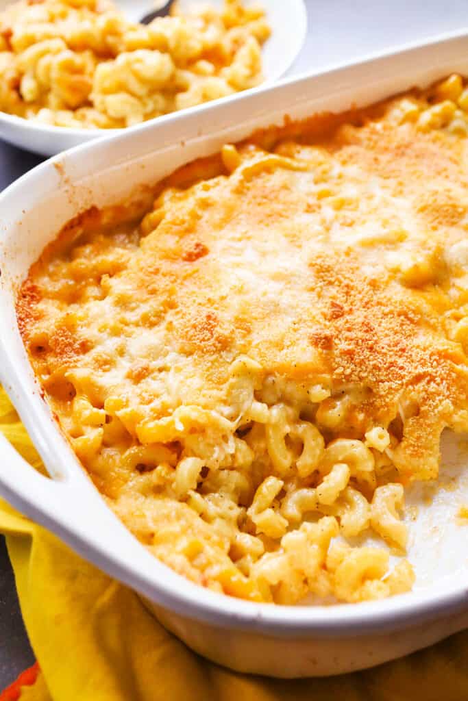 a serving dish of baked mac and cheese with a serving missing