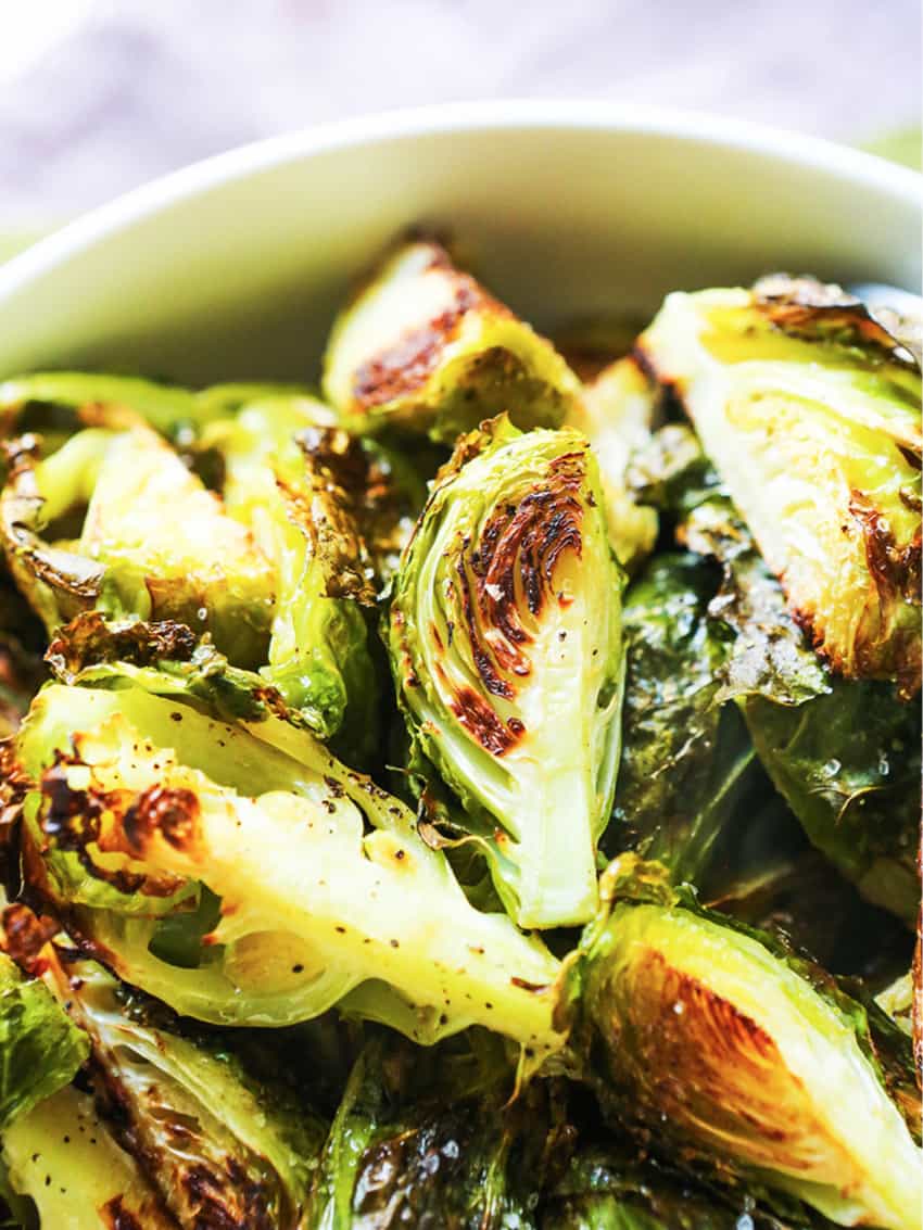 Close up of roasted brussels sprouts in a serving bowl.