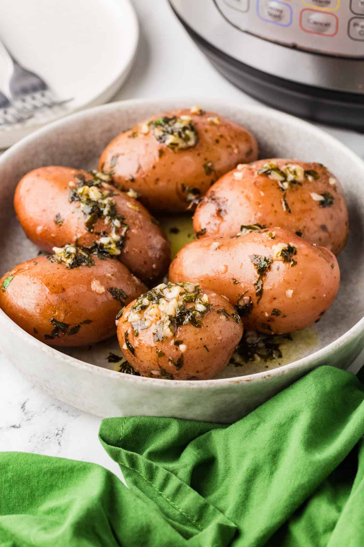 Serving bowl filled with red potatoes, sitting next to an Instant Pot.