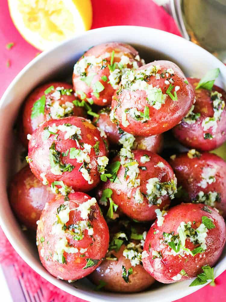 Top view of red potatoes with herbs in a serving bowl.