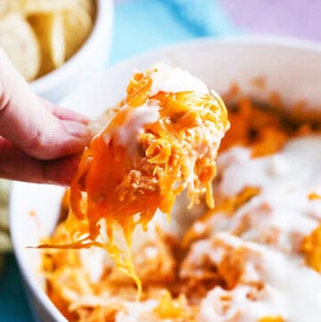 Creamy buffalo chicken dip with melted cheese and shredded chicken in a bowl.