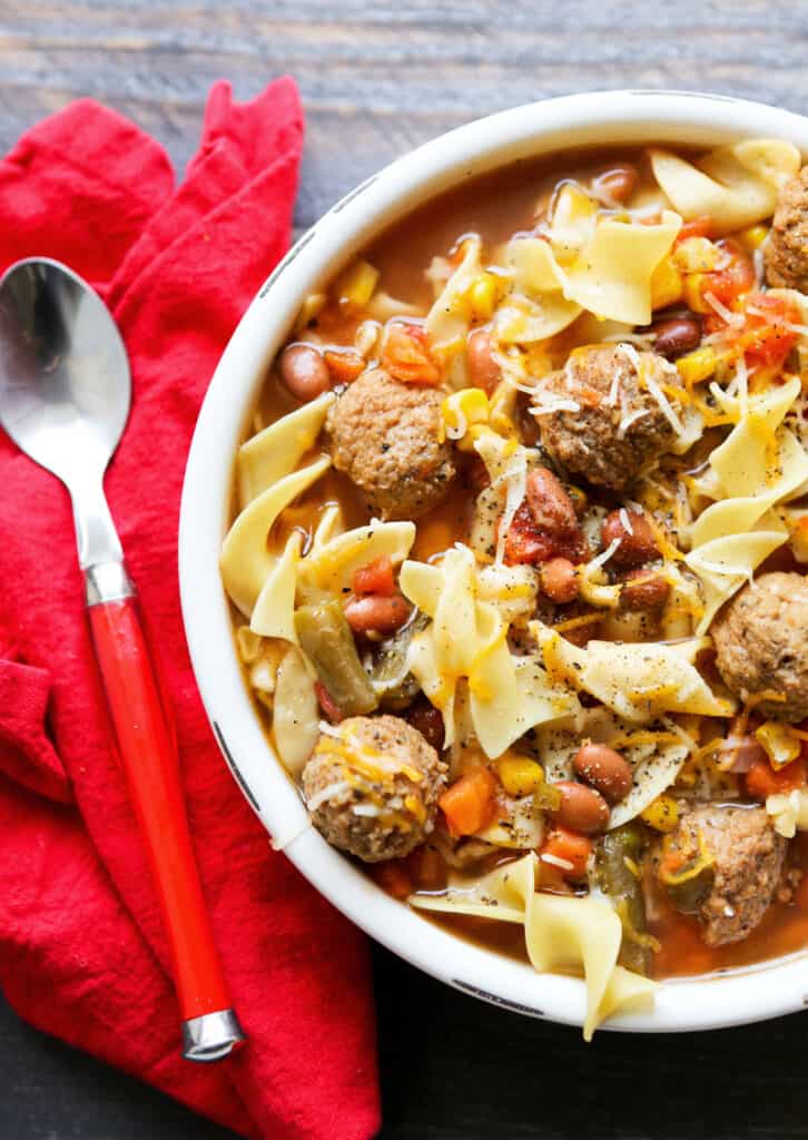 top view of a bowl of meatball soup with a spoon