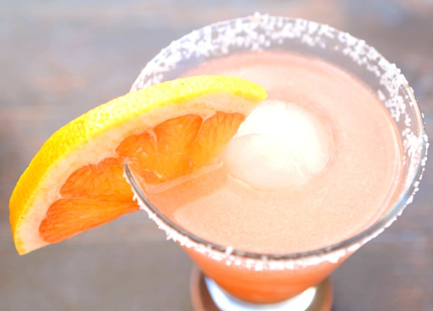 top view of a salty dog over ice in a glass with a garnish of grapefruit