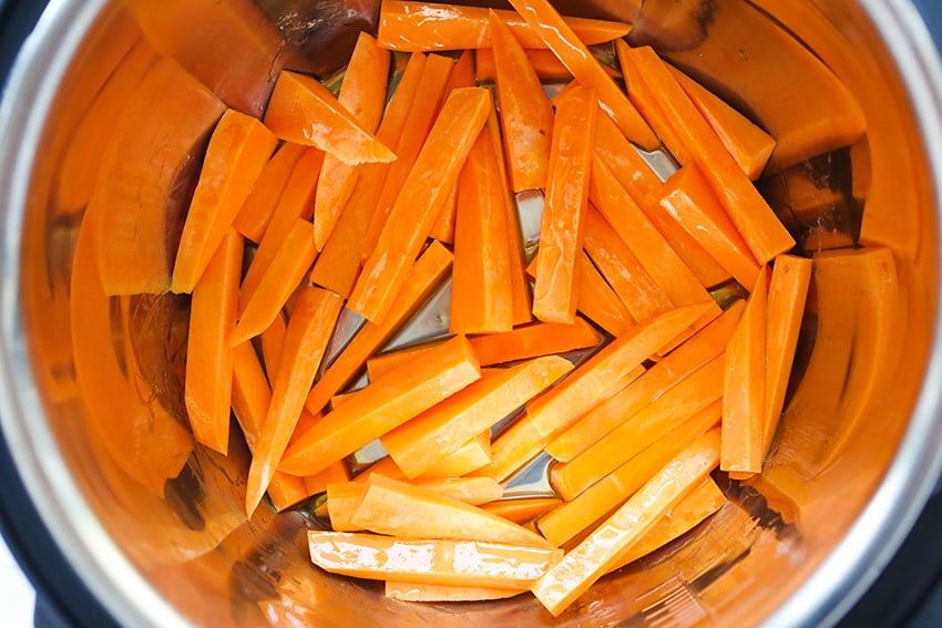 sweet potato fries in bottom of air fryer ready for air frying