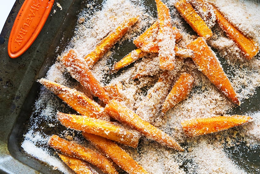 air fryer sweet potato fries on a baking sheet in a bed of sea salt