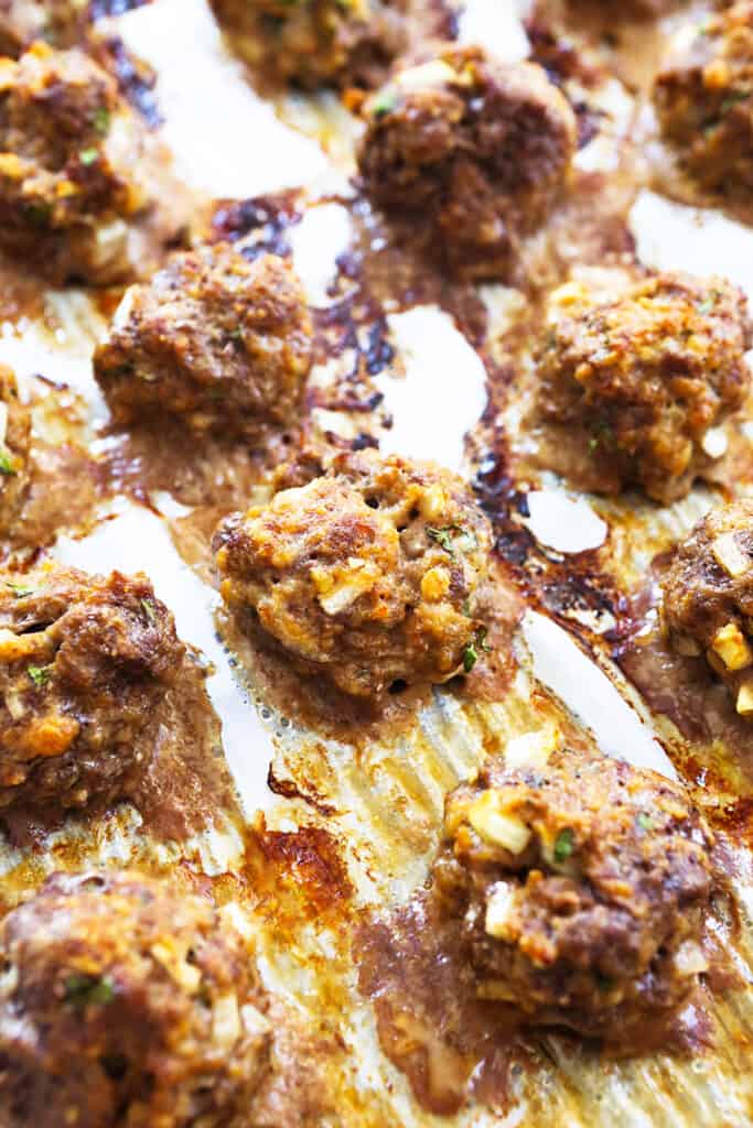 baked meatballs just out of oven on parchment paper.