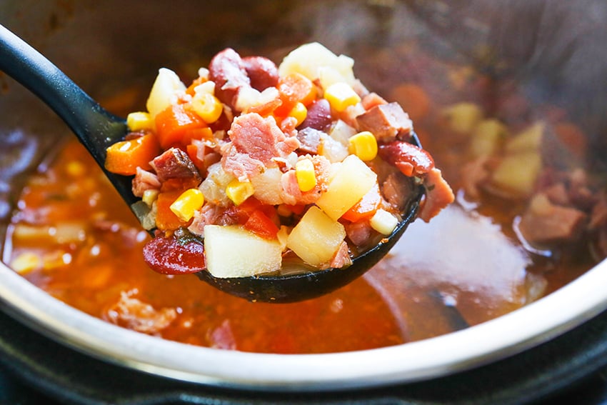 ladle filled with ham soup over the Instant Pot