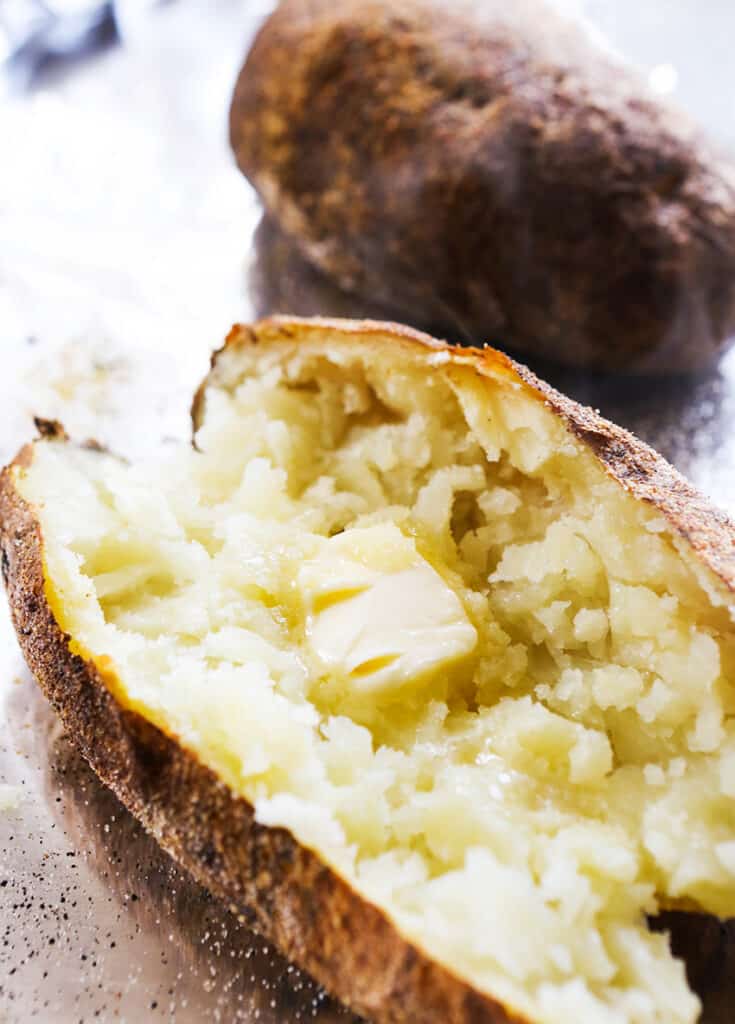 baked potato cut in half with pat of butter melting inside