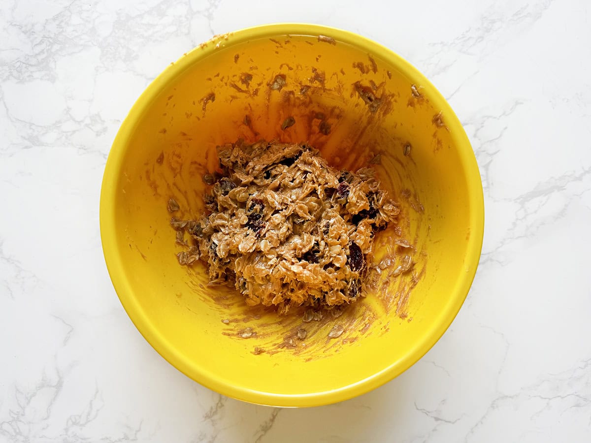 Protein bites mixture, stirred, in a yellow bowl.