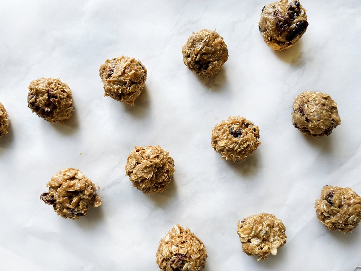 Snack bites rolled up and lined up on a sheet of parchment paper.