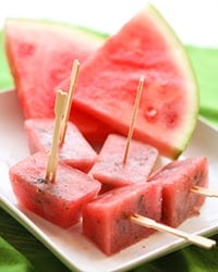 watermelon cubes with toothpicks on them sitting on a plate. 